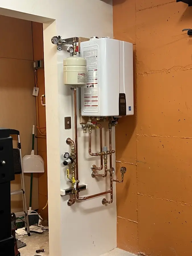 Plumbing technician inspecting water heater connections in Carencro